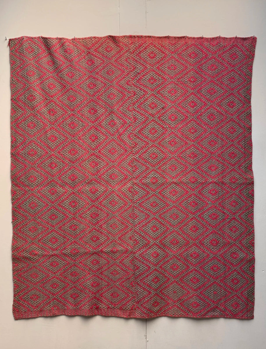 Full view of a Peruvian vintage handwoven wool rug featuring pink and green with Andean diamond patterns made with natural dyes.