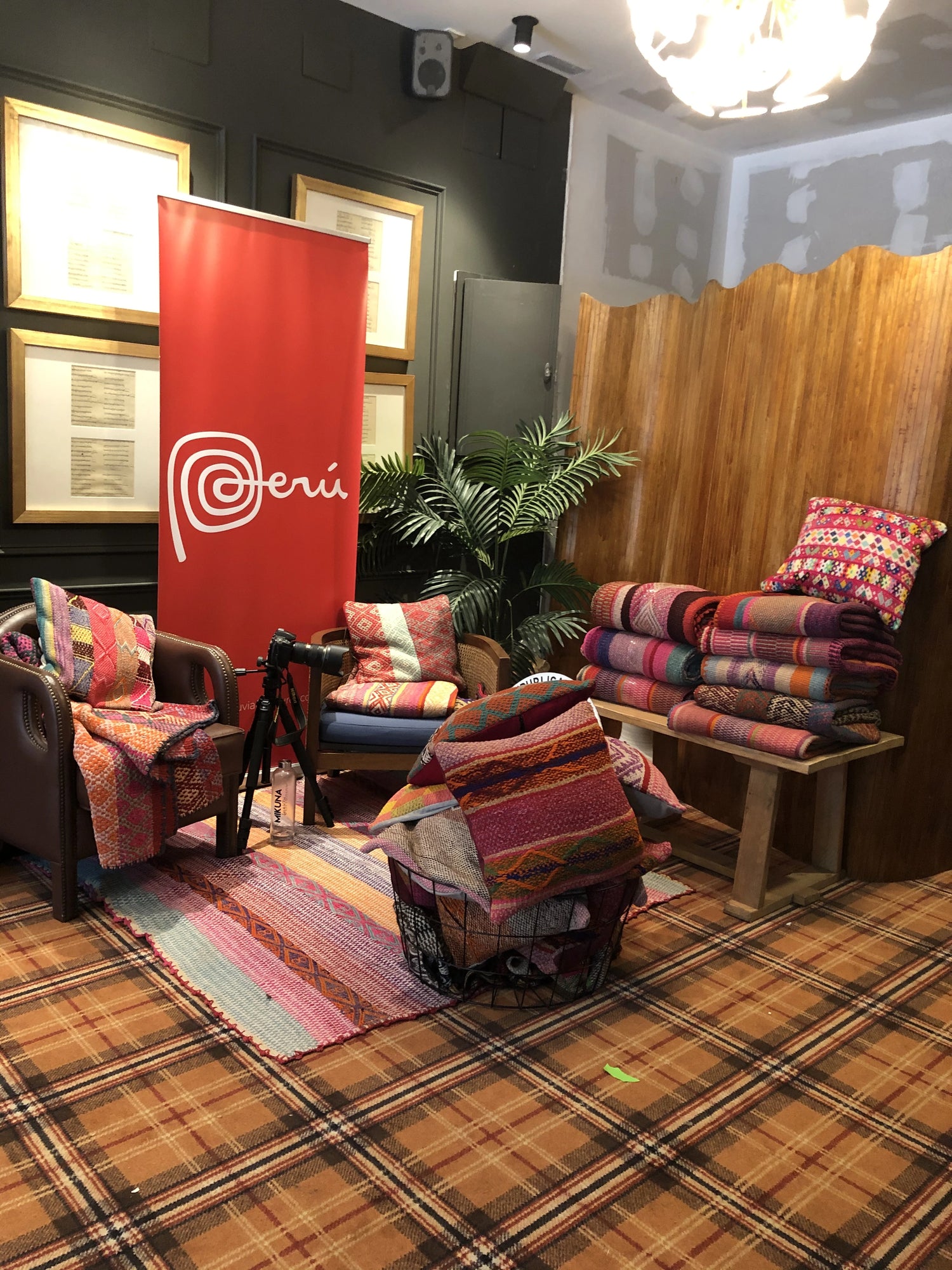 Peruvian handmade peruvian colorful wool rugs and pillow covers displayed on a couch and wooden table, into a decorative show room
